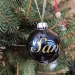boule noël bleue foncée, prénom "Sam" appliqué en vinyle doré.